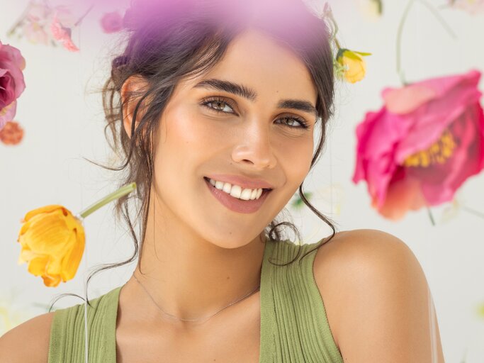 Schöne Frau mit blumigen, frühlingshaften Hintergrund | © GettyImages/svetikd