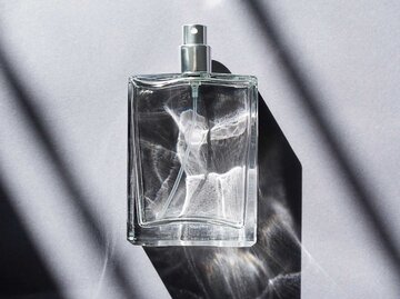 Transparente Flasche mit Parfum vor einem grauen Hintergrund | © Adobe Stock/Alex Shi