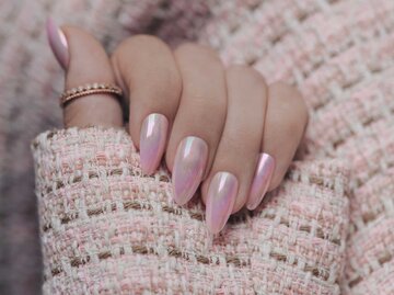 Eine Hand mit rosa lackierten Chrome Nails | © Adobe Stock/Dmitri