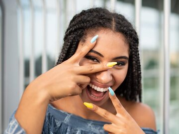 Frau mit blauen und gelben Fingernägeln | © Getty Images/Martin Novak