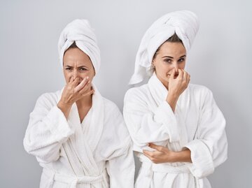 Zwei Frauen im Bademantel halten sich die Nase zu | © AdobeStock/Krakenimages.com