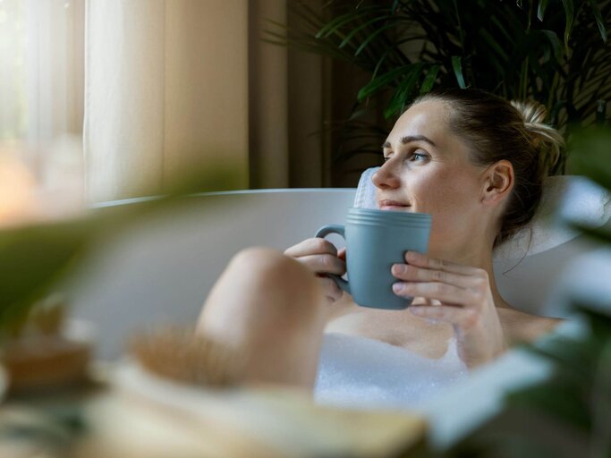 Person mit Tasse in Badewanne | © Getty Images/ronstik