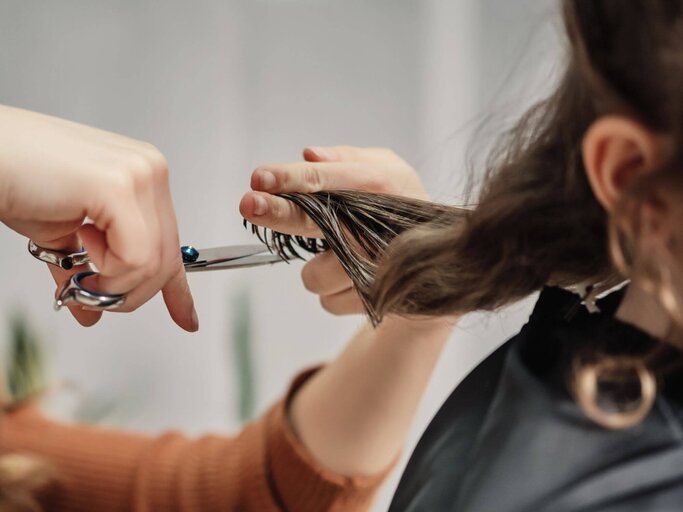 Person schneidet Haare | © Getty Images/SBenitez