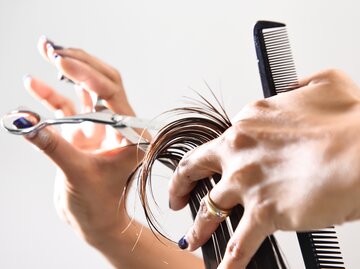 Eine Hand schneidet die Haare | © GettyImages/nimon_t