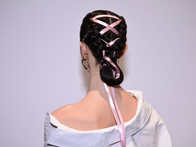 Ein Model trägt den Frisurentrend Ribbon Hair auf der Fashion Week. | © GettyImages/Dave Kotinsky / Freier Fotograf