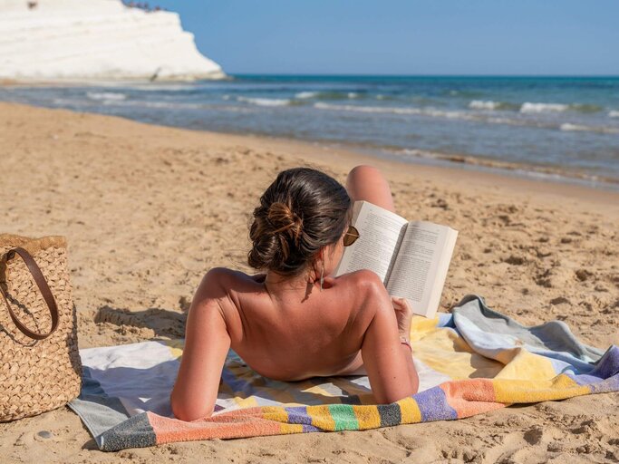 Person liest am Strand | © Getty Images/Francesco Vaninetti Photo