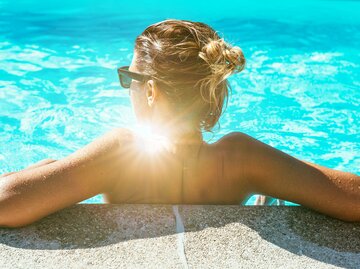 Frau mit blondem Dutt im Pool | © Getty Images/Drazen_
