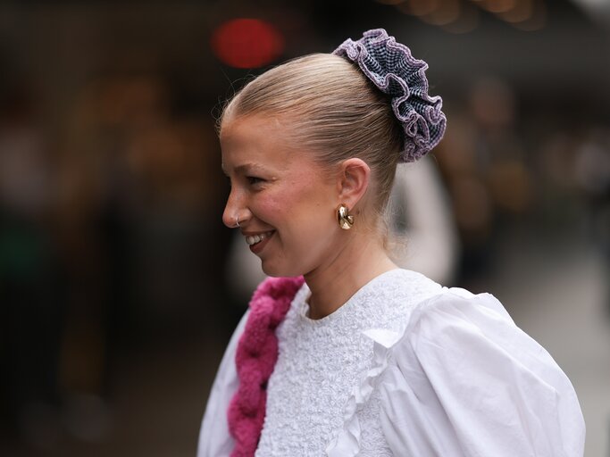 Streetstyle von blonder Frau mit Dutt und Scrunchie | © Getty Images/Jeremy Moeller