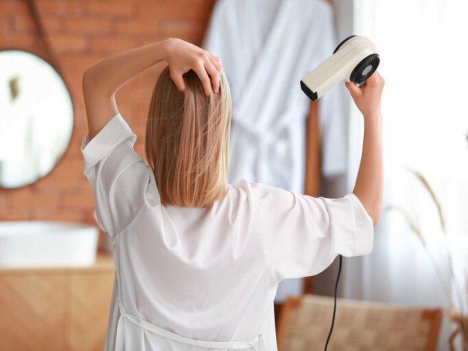 Frau mit blonden Haaren föhnt sie | © Adobe Stock/Pixel-Shot