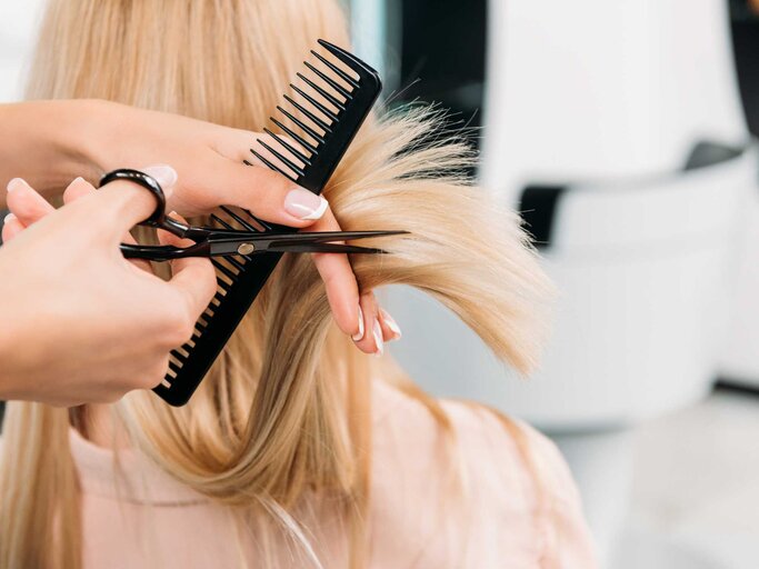 Blonde Haare werden mit einer Schere geschnitten | © Adobe Stock/LIGHTFIELD STUDIOS