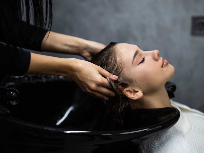 Frau werden beim Friseur die Haare gewaschen | © Adobe Stock/dianagrytsku