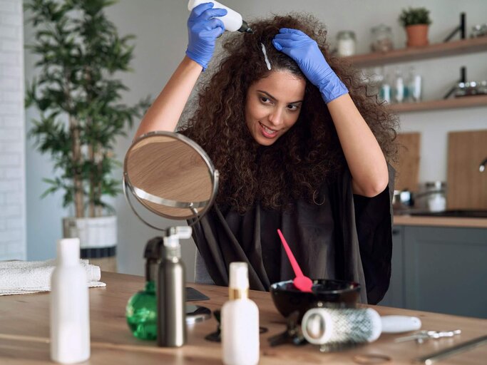 Person färbt sich Haare | © Getty Images/gpointstudio