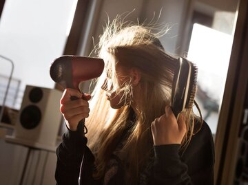 Person föhnt Haare | © Getty Images/Elva Etienne