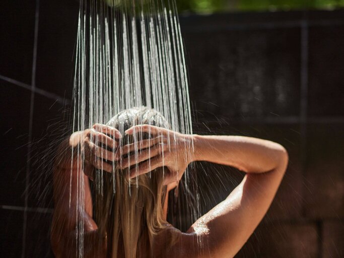 Person unter Dusche | © Getty Images/skynesher