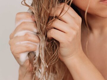 Frau reibt Conditioner in ihr nasses Haar ein | © Adobe Stock/Мapnha Aemewko