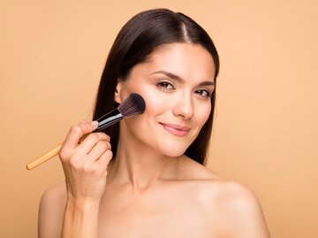 Frau trägt mit Make-up-Pinsel Rouge auf | © AdobeStock/deagreez