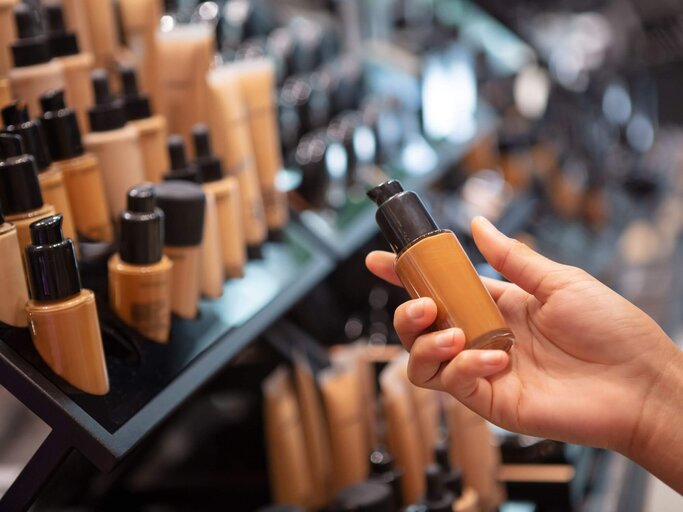 Hand hat Make-up-Flasche | © Getty Images/webphotographeer