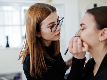 Make-up-Artist schminkt Frau | © Adobe Stock/AS Photo Family