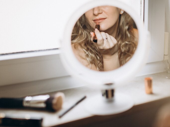 Frau trägt sich Lippenstift auf | © GettyImages/Liliya Krueger