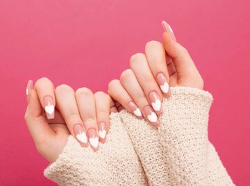 Frauenhände zeigen Nagellack mit Herzen | © Adobe Stock/Maya Kruchancova