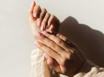 Weibliche Hände mit einer Maniküre in einem hellen Rosa. | © Getty Images/Anastasiia Krivenok