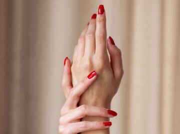Zwei Hände mit rot lackierten Fingernägeln | © Getty Images/Johner Images