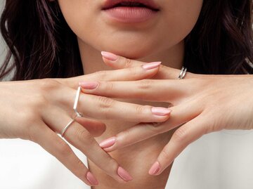 Frau mit rosa lackierten Nägeln und Ringen an den Fingern | © Adobe Stock/duyviet