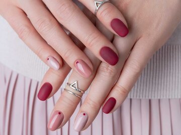 Kurze Nägel mit einem roten Nageldesign | © Adobe Stock/Darya Lavinskaya