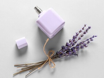 Lila Parfum-Flakon und ein Lavendel-Strauch auf weißem Hintergrund | © Adobe Stock/Pixel-Shot
