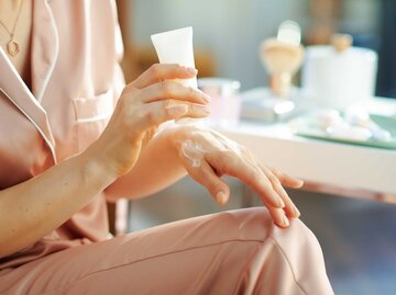 Frau cremt sich ihre Hände mit Handcreme ein | © Adobe Stock/Alliance