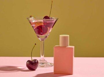 Parfum-Flakon und Kirschen in einem Cocktailglas | © Adobe Stock/Tuan Nguyen