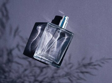 Parfum-Flakon vor einem blauen Hintergrund | © Adobe Stock/Alex Shi