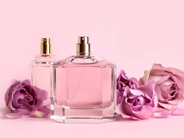 Parfum-Flakons und Blumen vor einem rosa Hintergrund | © Adobe Stock/New Africa