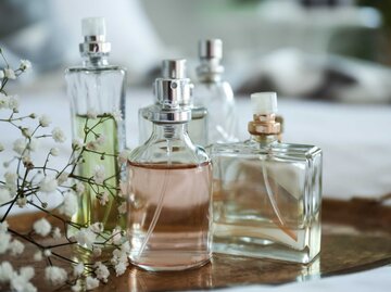 Bunte Parfum-Flakons und Blumen auf einem Metalltablett | © Adobe Stock/Pixel-Shot