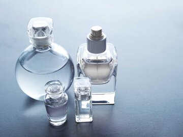 Parfum-Flakons vor blauem Hintergrund | © Adobe Stock/Africa Studio