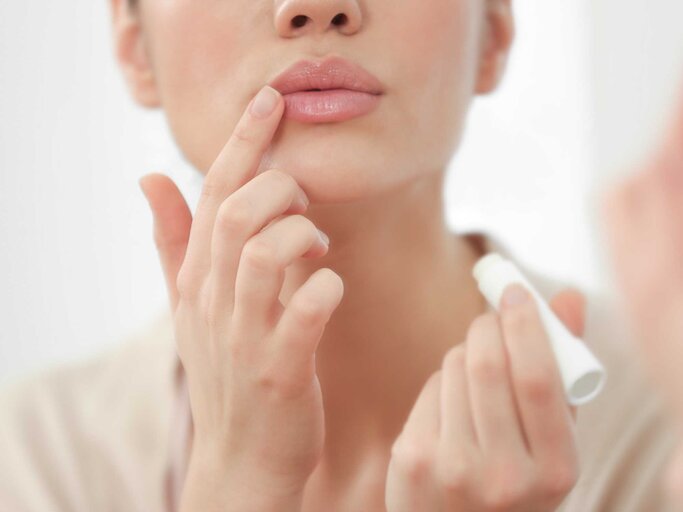 Frau benutzt einen Lippenpflegestift | © Adobe Stock/Africa Studio