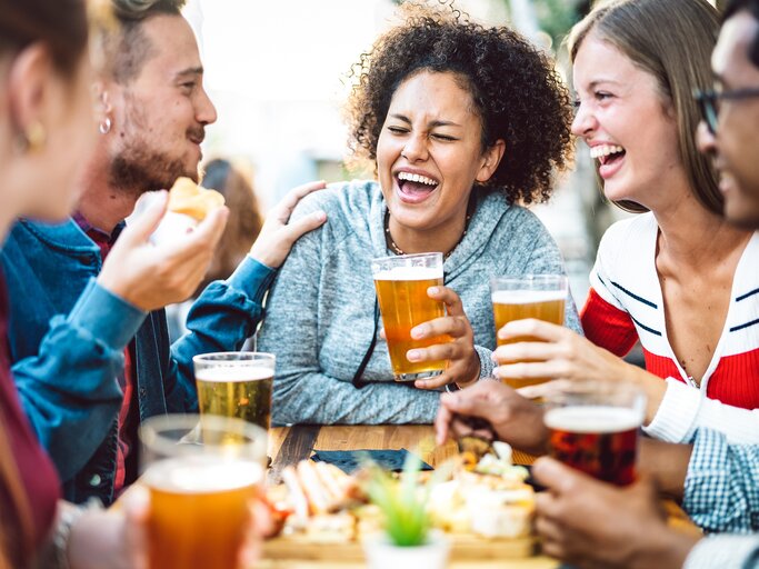 Lachende Menschen im Biergarten | © GettyImages/ViewApart