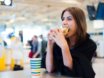 Person isst Sandwich an Flughafen | © Getty Images/VladTeodor