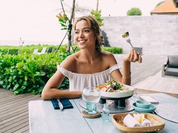 Person im Urlaub beim Essen | © Getty Images/GaudiLab