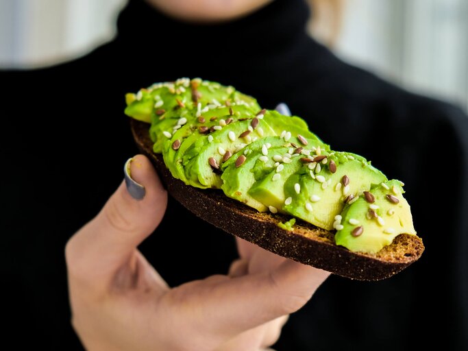 Frau mit Avocadobrot in der Hand | © Getty Images/Anastasiia Yanishevska / EyeEm
