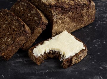 Haferflocken-Brot aufgeschnitten, Scheibe Brot mit Butter | © Getty Images/R.Tsubin