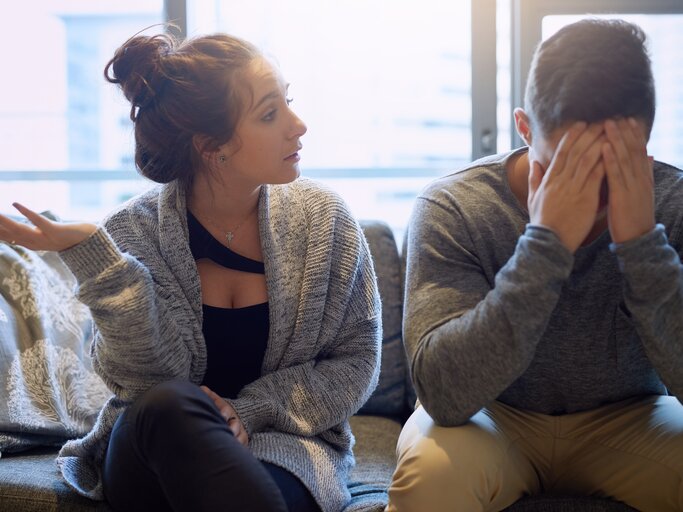 Junge Frau schreit ihren Partner an, der den Kopf in die Hände legt  | © Getty Images/PeopleImages