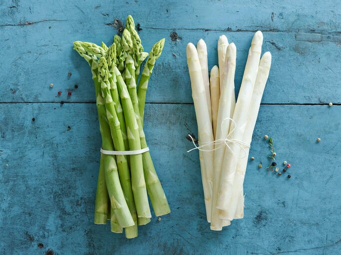 Grüner und weißer Spargel von oben auf blauem Hintergrund fotografiert | © Getty Images/Westend61