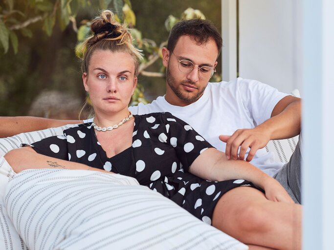 Gelangweilte Frau mit Mann auf Couch | © Getty Images/Westend61