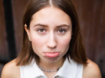 Junge Frau streckt beleidigt ihre Unterlippe nach vorne. | © Getty Images/Sergio Mendoza Hochmann