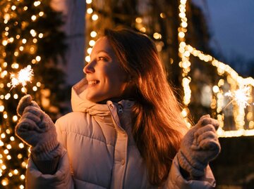 Frau hält zwei Wunderkerzen | © Adobe Stock/Daryna