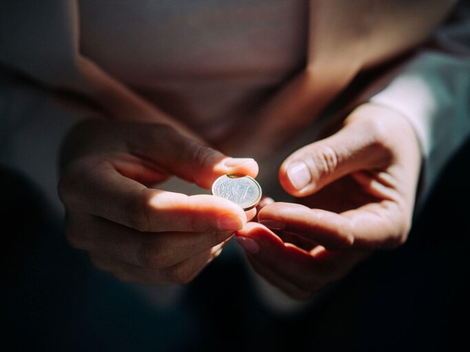 Person hat Euro in der Hand | © Getty Images/Guido Mieth