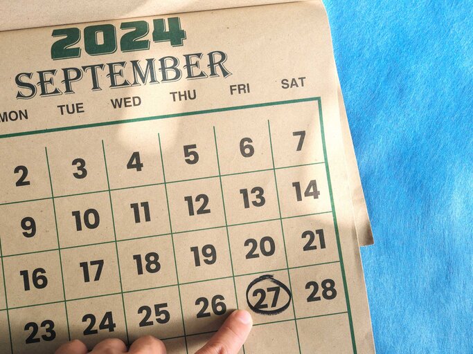 Ein Finger zeigt auf den 27. September 2024 auf einem braunen Wandkalender. | © Adobe Stock/sulit.photos