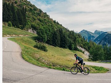 Mann radelt endlose Straße entlang. | © Getty Images/Justin Paget