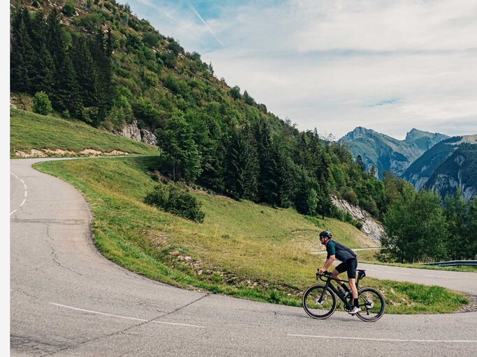 Mann radelt endlose Straße entlang. | © Getty Images/Justin Paget